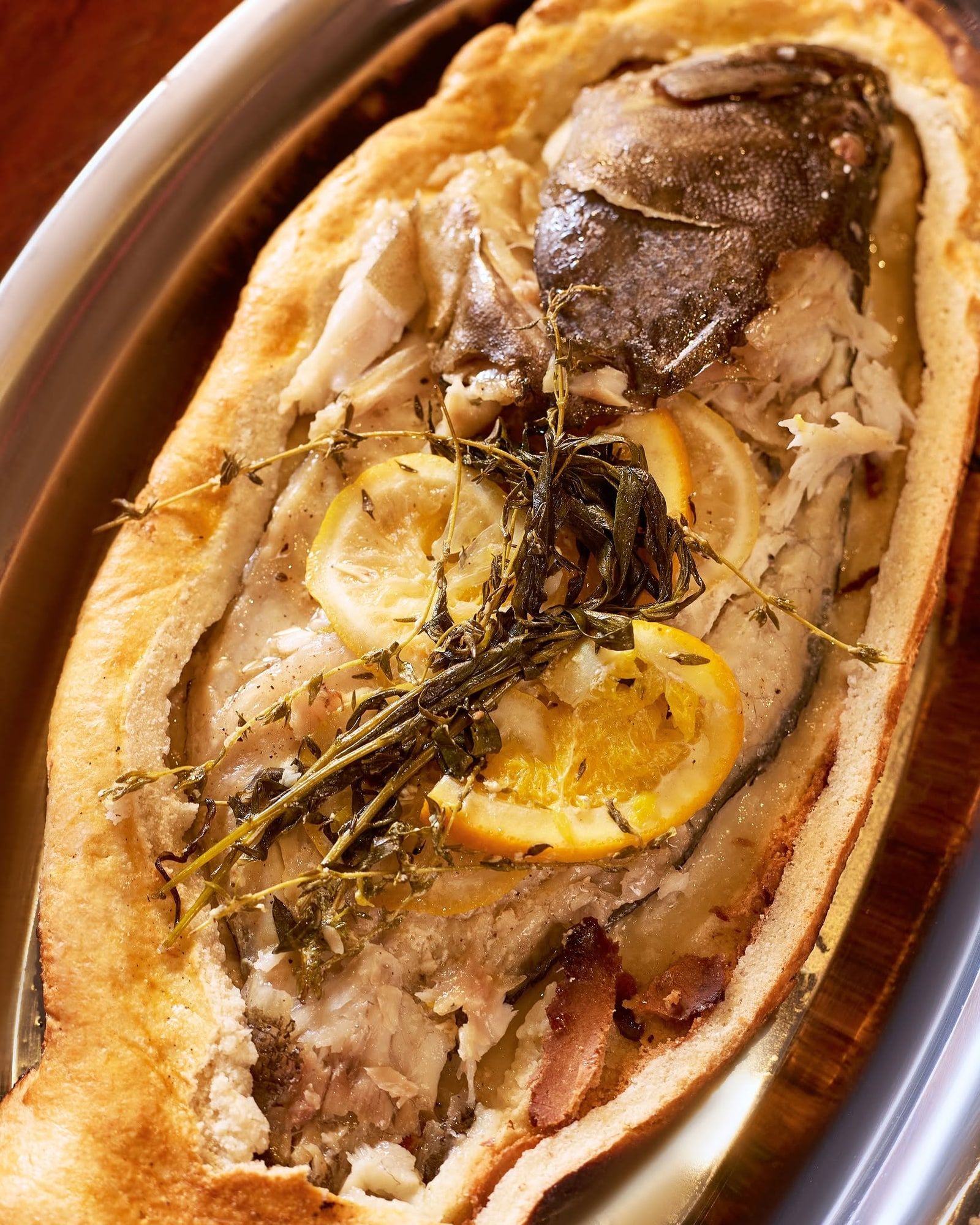 Vỏ bánh được mở, cá cùng thảo mộc và chanh