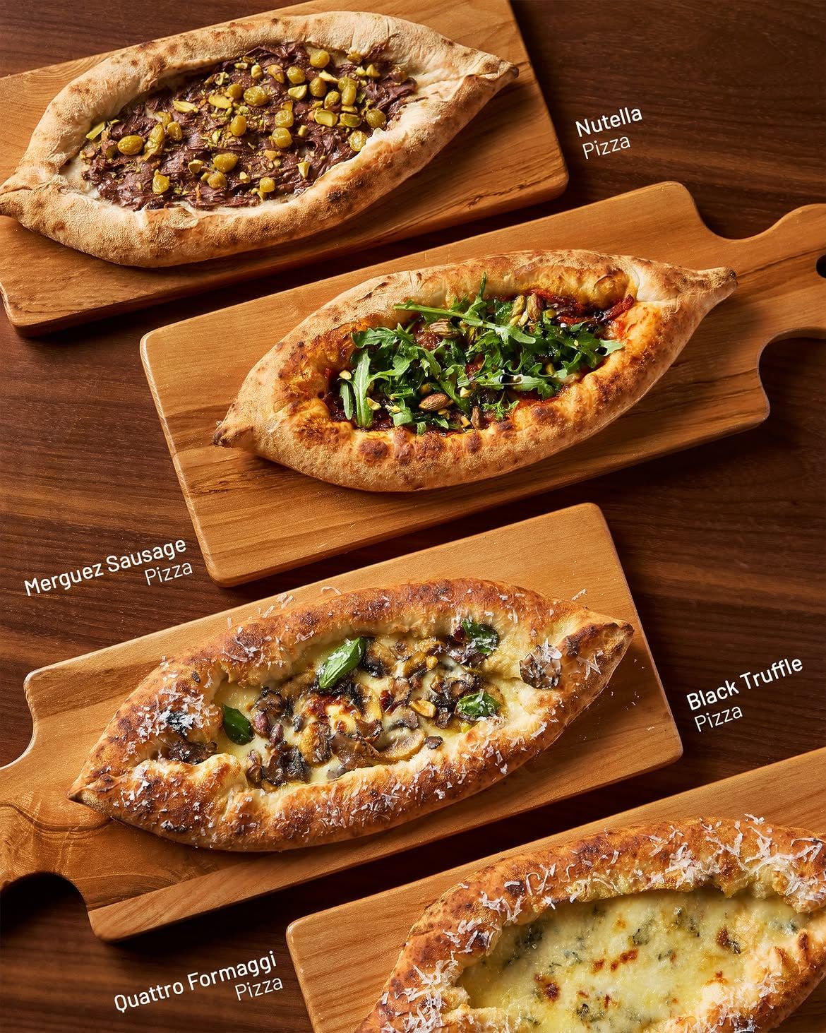 Bốn chiếc pizza trên thớt gỗ: Nutella, Merguez Sausage, Black Truffle, Quattro Formaggi